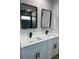 Bathroom with double vanity featuring white cabinets, modern sinks and faucets, and mirrors with black frames at 10641 Sw 110Th Ct, Dunnellon, FL 34432