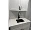 Stylish laundry room features a white cabinet, quartz countertop, black sink and black hardware at 10641 Sw 110Th Ct, Dunnellon, FL 34432