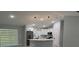 Open-concept living room and kitchen area with modern lighting and large windows at 10641 Sw 110Th Ct, Dunnellon, FL 34432