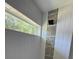 Light and airy shower featuring white tiling, a horizontal window, and a vertical accent of mosaic tiling at 10641 Sw 110Th Ct, Dunnellon, FL 34432