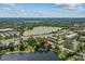 Aerial view of a home near a tranquil lake, a busy street, and commercial buildings surrounded by green trees at 11 Plumosa Ave, Casselberry, FL 32707