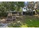 Spacious backyard featuring a wooden firepit, lush lawn, and access to an enclosed sunroom, ideal for outdoor entertaining at 11 Plumosa Ave, Casselberry, FL 32707
