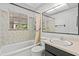 Well-lit bathroom with a shower, tub, vanity, and tiled walls at 11 Plumosa Ave, Casselberry, FL 32707