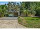 Inviting exterior view of a charming single-story home with a covered carport, driveway, and lovely landscaping at 11 Plumosa Ave, Casselberry, FL 32707