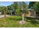 A well-manicured front yard showcases a quaint home with lush green grass and mature trees at 11 Plumosa Ave, Casselberry, FL 32707