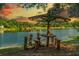 A picturesque lake view featuring a unique rustic picnic table and breathtaking sky at 11 Plumosa Ave, Casselberry, FL 32707