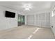 Spacious living room with carpet, features access to enclosed porch and dual closets, providing ample storage at 11 Plumosa Ave, Casselberry, FL 32707