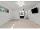 Bright living room features neutral carpet, ceiling fan, and an adjacent bathroom, offering comfortable living space at 11 Plumosa Ave, Casselberry, FL 32707