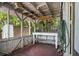 An enclosed outdoor porch featuring a workbench, weathered wood, and glimpses of the surrounding greenery at 11 Plumosa Ave, Casselberry, FL 32707