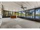 Enclosed sunroom with carpet, ceiling fan and tranquil water views, perfect for year-round enjoyment at 11 Plumosa Ave, Casselberry, FL 32707