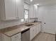 Updated kitchen with white cabinetry, granite countertops and stainless steel dishwasher at 11282 Sw 62Nd Avenue Rd, Ocala, FL 34476