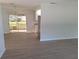 Bright open-concept living area with stylish vinyl flooring and a view of the sunroom at 11282 Sw 62Nd Avenue Rd, Ocala, FL 34476