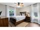 Cozy bedroom with wood-look tile floors, modern ceiling fan, large windows, and stylish furniture at 1172 Trotwood Blvd, Winter Springs, FL 32708
