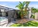 Exterior view of home with a screened-in patio and lush tropical landscaping at 1172 Trotwood Blvd, Winter Springs, FL 32708