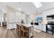 Well-lit kitchen featuring a skylight, white cabinets, a kitchen island, and modern appliances at 1172 Trotwood Blvd, Winter Springs, FL 32708
