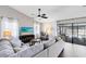 Bright and airy living room featuring a large sofa, wood floors, and access to outdoor pool area at 1172 Trotwood Blvd, Winter Springs, FL 32708