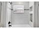 Bathroom shower with white tiles, built in shelves, shower head, and a window at 1172 Trotwood Blvd, Winter Springs, FL 32708