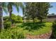 Serene backyard view featuring a peaceful pond, lush green grass, and beautiful landscaping at 12185 Obelia Ln, Orlando, FL 32827