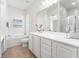 Bright bathroom featuring a large mirror, double vanity, tub, and tiled floors at 12185 Obelia Ln, Orlando, FL 32827