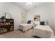 Bright bedroom featuring two twin beds, neutral decor, and a built-in bookshelf at 12185 Obelia Ln, Orlando, FL 32827
