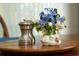 Close-up of dining centerpiece with blue flowers, salt/pepper shakers and small ceramic duck at 12185 Obelia Ln, Orlando, FL 32827