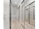 Hallway featuring a mirrored closet and a view to an adjacent bathroom at 12185 Obelia Ln, Orlando, FL 32827