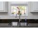 Kitchen sink featuring a modern faucet, granite countertop, and a view of the outdoors through the window at 12185 Obelia Ln, Orlando, FL 32827