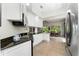 Modern kitchen featuring granite countertops, white cabinetry, stainless steel appliances, and tile floor at 12185 Obelia Ln, Orlando, FL 32827