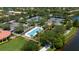 Aerial view of lap pool, tennis courts, parking, and lake in a landscaped residential community at 12185 Obelia Ln, Orlando, FL 32827