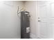 A clean and functional water heater in a utility space with a white door at 12185 Obelia Ln, Orlando, FL 32827