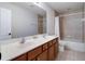 Bathroom with double sinks, tile floors, wood cabinets, and shower/tub combination at 13156 Hatherton Cir, Orlando, FL 32832