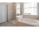 Bathroom features a walk-in shower with glass door and separate soaking tub at 13156 Hatherton Cir, Orlando, FL 32832