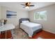 Bedroom with ceiling fan, wood floors, and bright window with nature view at 13156 Hatherton Cir, Orlando, FL 32832