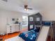Fun bedroom features a bunk bed with slide, ceiling fan, wood floors, and large dresser at 13156 Hatherton Cir, Orlando, FL 32832