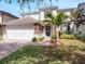 Charming two-story home featuring a stone facade, well-manicured lawn, and an attached two-car garage at 13156 Hatherton Cir, Orlando, FL 32832
