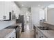 Open kitchen features stainless steel appliances, granite countertops, and white cabinets with black hardware at 13156 Hatherton Cir, Orlando, FL 32832