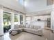 Bright living room features large windows, high ceilings, tile flooring, and a comfortable sectional sofa and kitchen at 13156 Hatherton Cir, Orlando, FL 32832