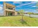 Well-maintained backyard featuring a covered patio and upper balcony with a grassy lawn at 14078 Alafaya Oak Bnd, Orlando, FL 32828