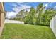 Large grassy backyard surrounded by white vinyl and black iron fencing providing privacy at 14078 Alafaya Oak Bnd, Orlando, FL 32828