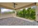 This covered balcony features brick pavers, a ceiling fan, and a beautiful view of the trees at 14078 Alafaya Oak Bnd, Orlando, FL 32828