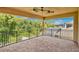 Outdoor covered patio balcony featuring brick flooring, a metal railing, and wooded views at 14078 Alafaya Oak Bnd, Orlando, FL 32828
