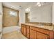 Bathroom with double vanity, granite counters, tile flooring, and a bathtub at 14078 Alafaya Oak Bnd, Orlando, FL 32828