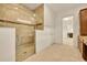 Bathroom featuring a tiled shower with glass door, wood cabinets, and view into the laundry room at 14078 Alafaya Oak Bnd, Orlando, FL 32828