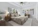 Bright bedroom features neutral décor, tray ceiling, ceiling fan, and large windows at 14078 Alafaya Oak Bnd, Orlando, FL 32828