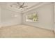 Large bedroom with a ceiling fan and natural light coming from the window, with a carpet flooring at 14078 Alafaya Oak Bnd, Orlando, FL 32828