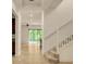 Bright entryway with staircase, tile flooring, and sliding glass doors to the backyard at 14078 Alafaya Oak Bnd, Orlando, FL 32828