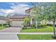 Charming two-story home with a brick driveway, manicured lawn, and vibrant landscaping at 14078 Alafaya Oak Bnd, Orlando, FL 32828
