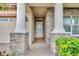 Inviting front porch with stone accents and stately columns, leading to the front door at 14078 Alafaya Oak Bnd, Orlando, FL 32828
