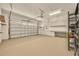 An empty two car garage with white walls and a neutral epoxy floor finish at 14078 Alafaya Oak Bnd, Orlando, FL 32828