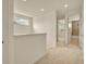 Bright hallway with neutral carpet and railing, leading to bedrooms and a bathroom at 14078 Alafaya Oak Bnd, Orlando, FL 32828